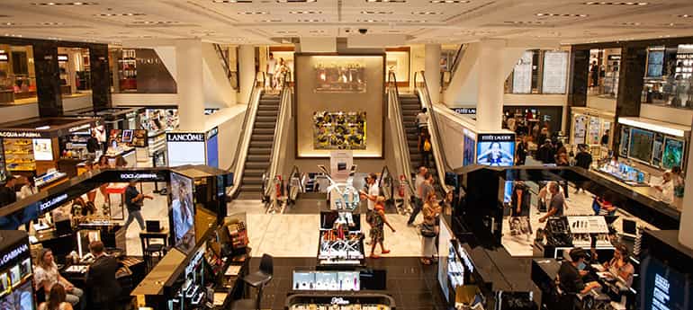 high angle photo of a retail store with makeup and jewelry counters and escalators